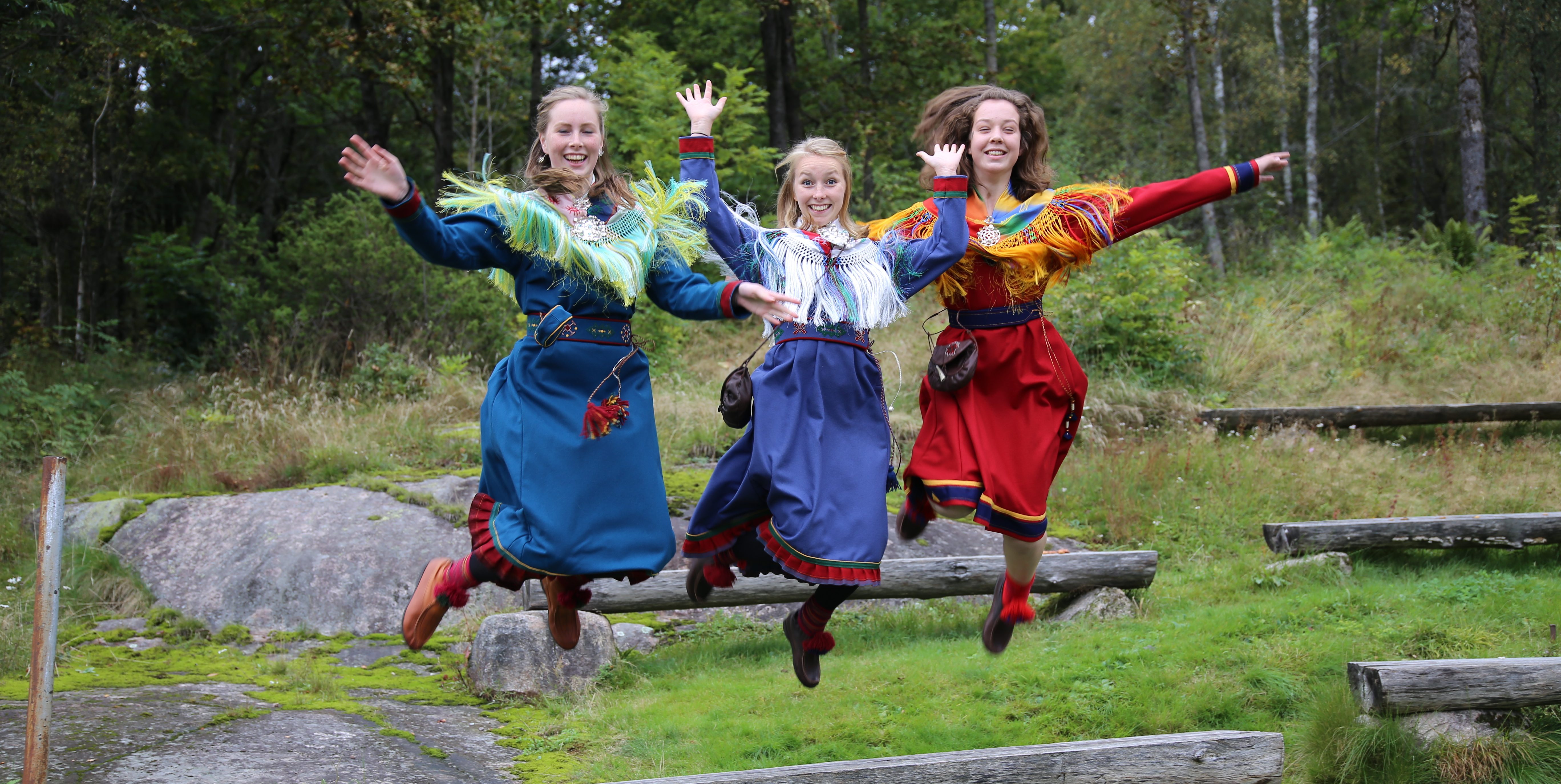 jenter i samiske kofter som hopper
