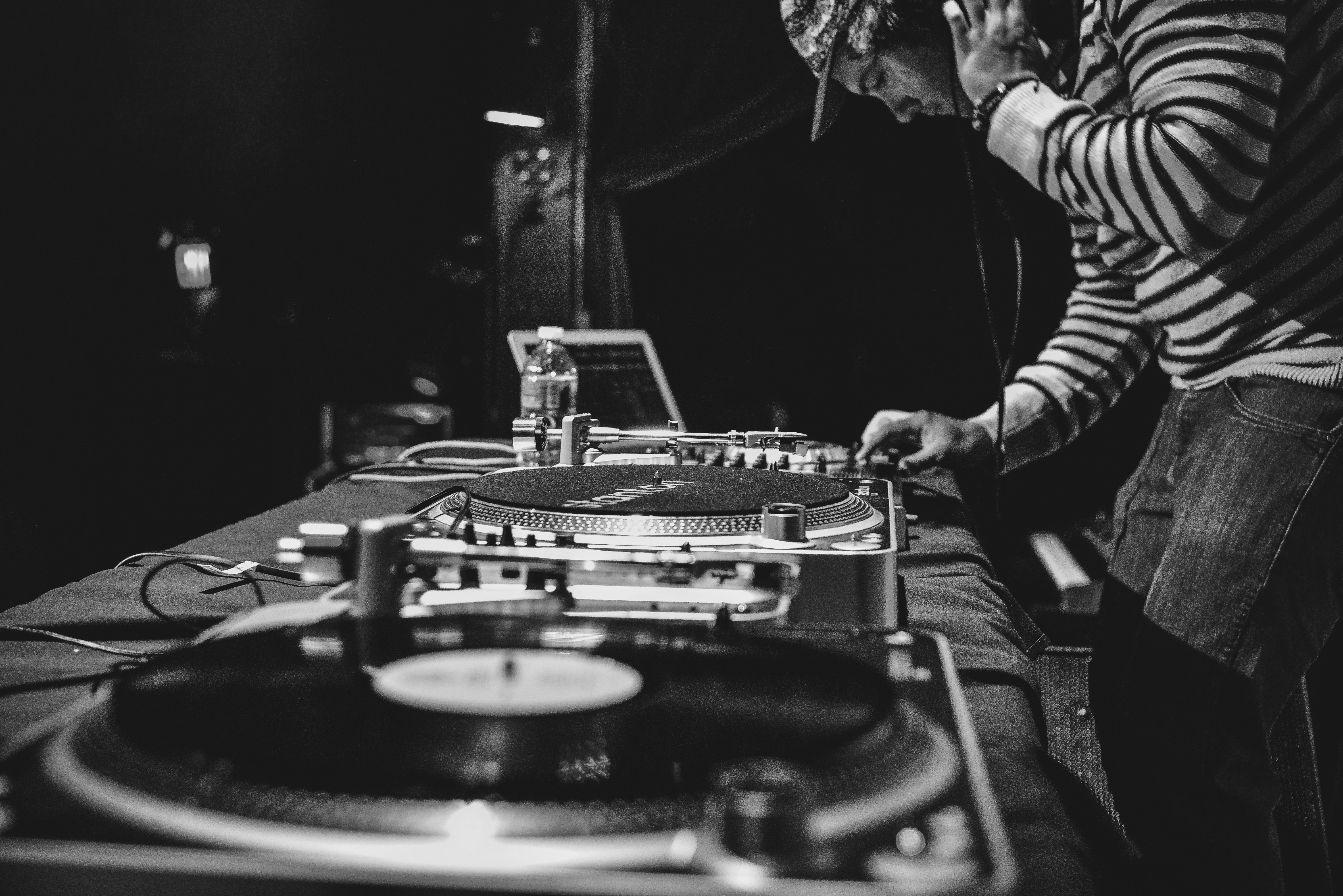 DJ som mikser musikk på vinylspiller og mikser