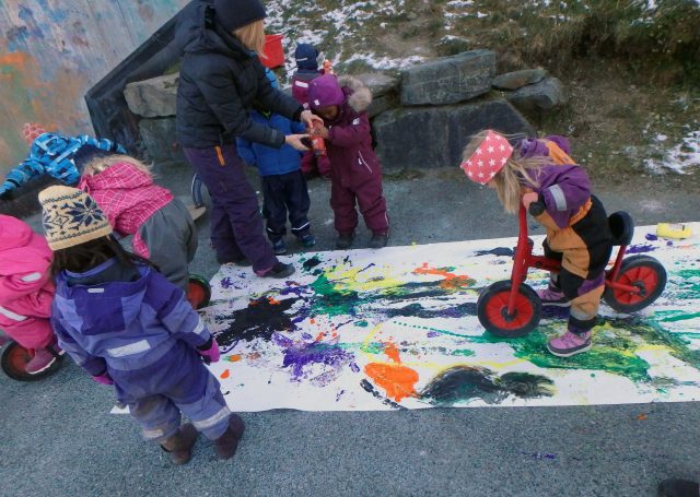 Barn lager kunst med maling og sykler