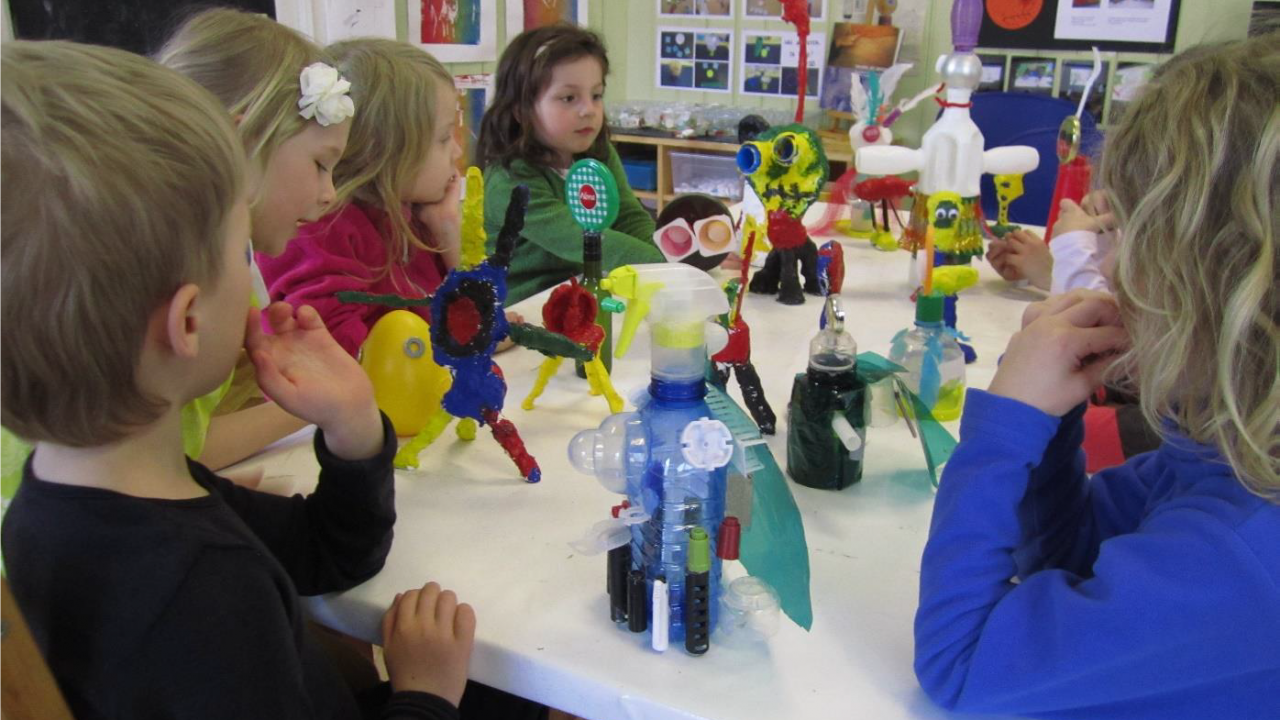 Barn lager skulpturer av gjenbruksmateriale og limpistol.
