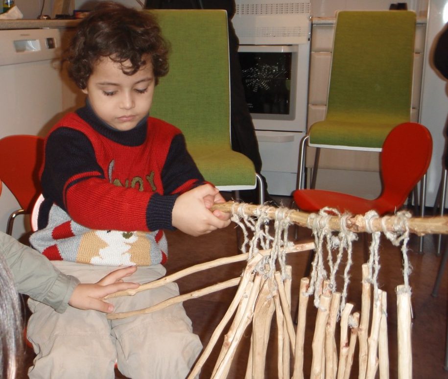 Barn eksperimenterer med lyd av trepinner.