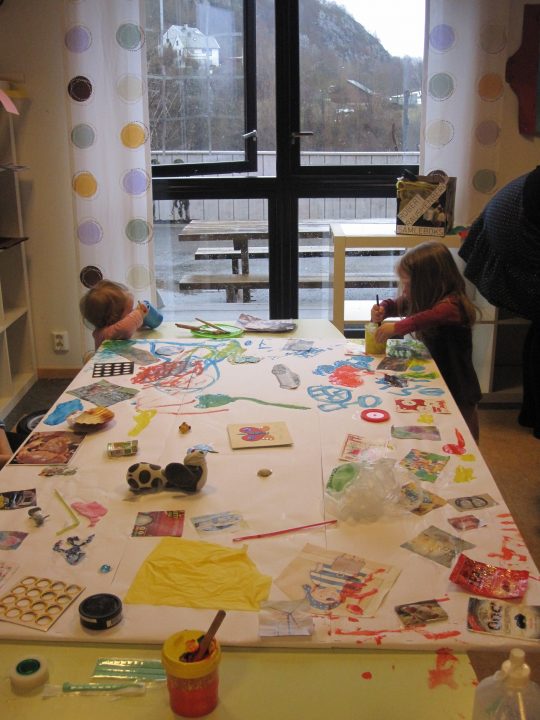 Barn som lager kunst ved et bord.
