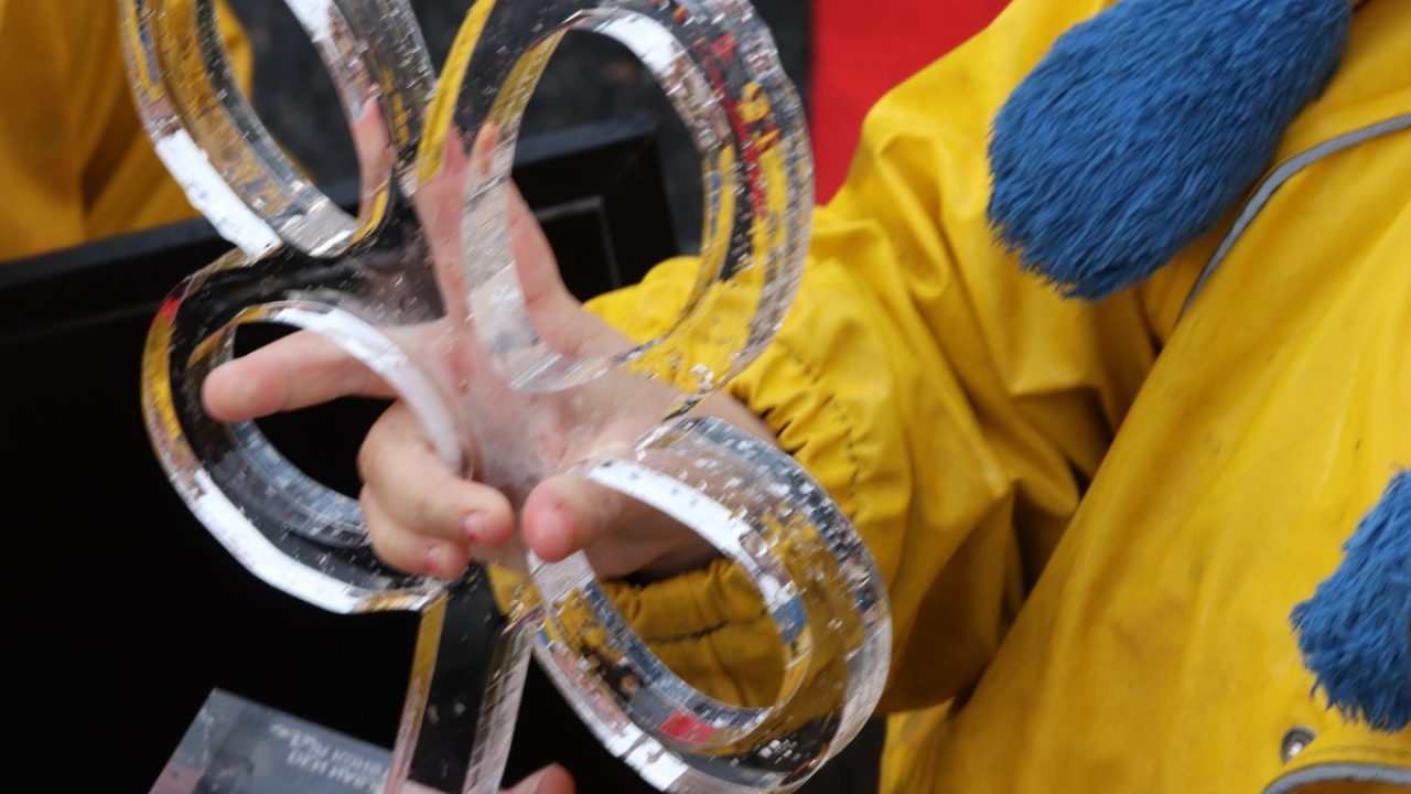 Barn holder skulptur i transparent materiale.
