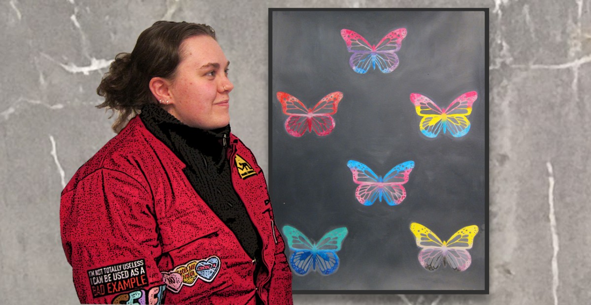Ung kvinne står foran et maleri av sommerfugler.