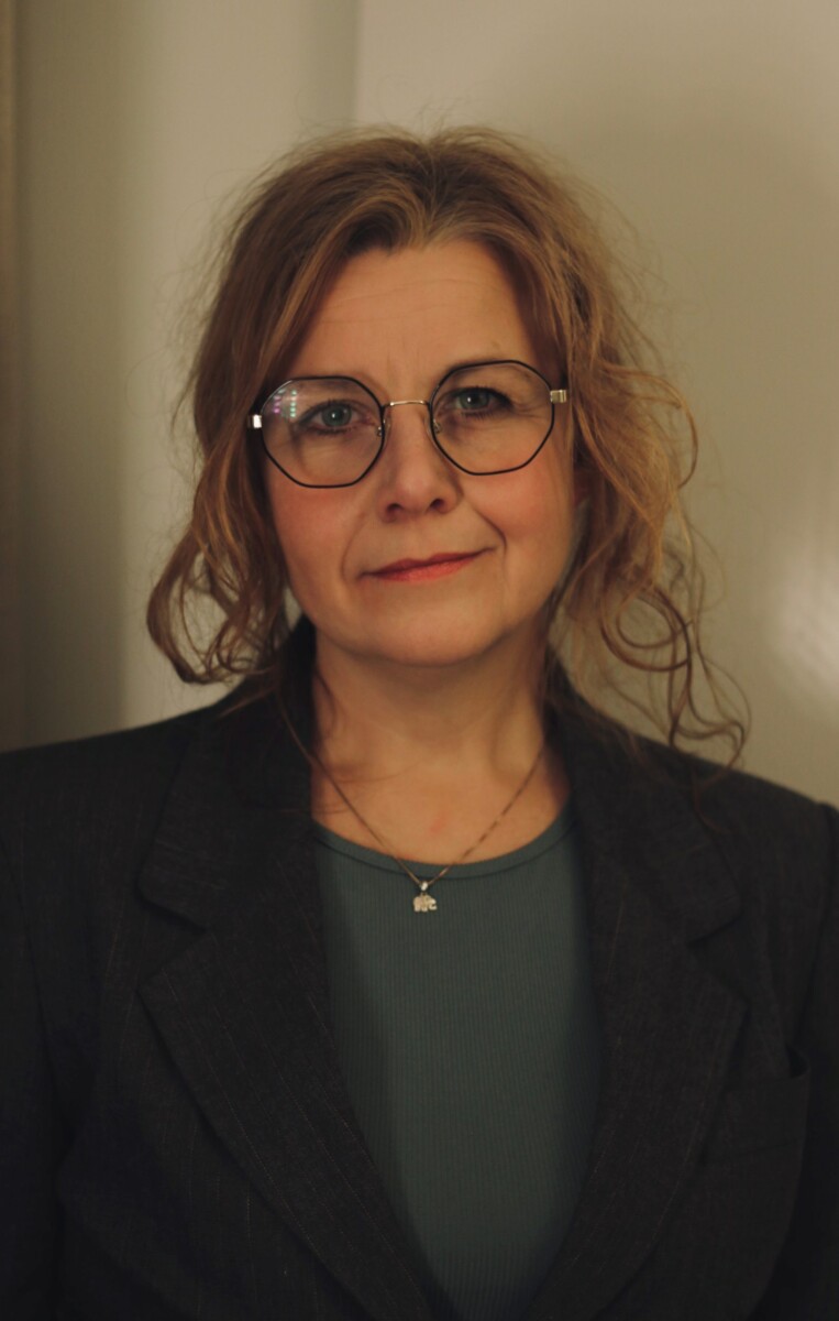Bilde av en dame med briller. Mørke klær